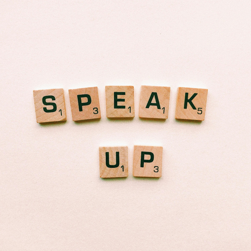Scrabble game pieces that say "Speak Up"