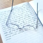 Journal with handwritten page and pair of readers